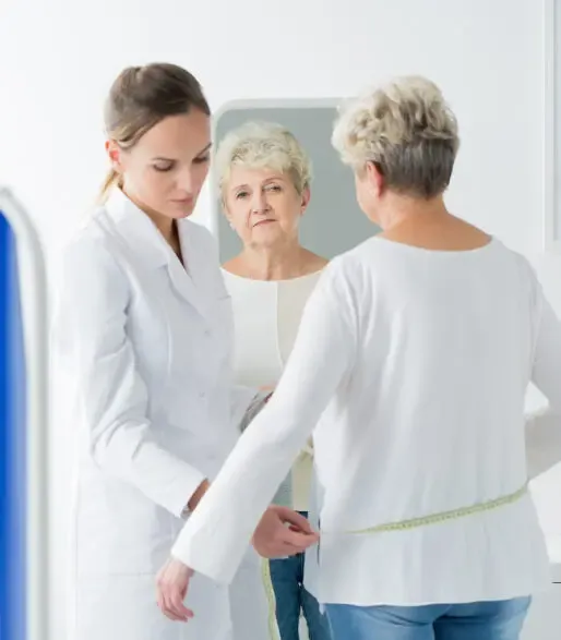 Dolce MD doctor and woman reviewing weight loss progress in front of a mirror in Laguna Beach clinic