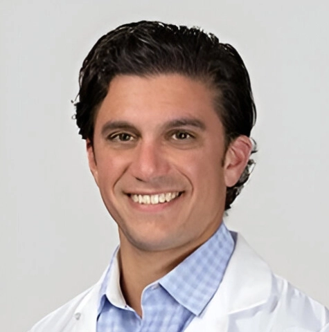 Portrait of Dr. John Sanguedolce in a white lab coat at his medical office